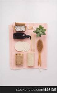 Zero waste, Recycling, Sustainable lifestyle concept. Eco-friendly bathroom accessories: toothbrushes, reusable cotton make up removal pads, make up remover in a glass container, natural brush, bamboo ear sticks, olive oil soap. Flat lay. Zero waste concept. Eco-friendly bathroom accessories, flat lay