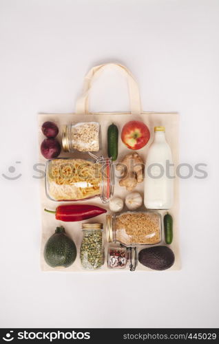 Zero waste shopping concept. Eco bag with fruits and vegetables, glass jars with beans, lentils, pasta. Eco-friendly shopping, flat lay. Zero waste shopping concept, flat lay, top view