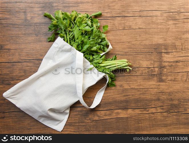 Zero waste use less plastic concept / Fresh vegetables organic in eco cotton fabric bags on wooden table - white tote canvas cloth bag from market free plastic shopping