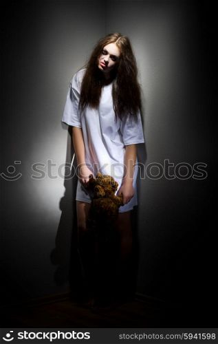 Zombie girl with teddy bear on black