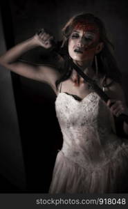 Zombie lady corpse holding sword to kill herself while wedding. Horror and Ghost concept for Halloween's day theme event. Dark and grunge tone film