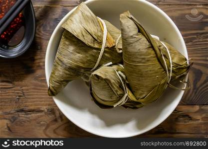 Zongzi, a traditional food for dragon boat festival and chili sauce on distressed wood