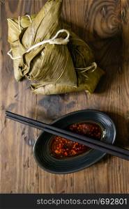 Zongzi, a traditional food for dragon boat festival and chili sauce on distressed wood