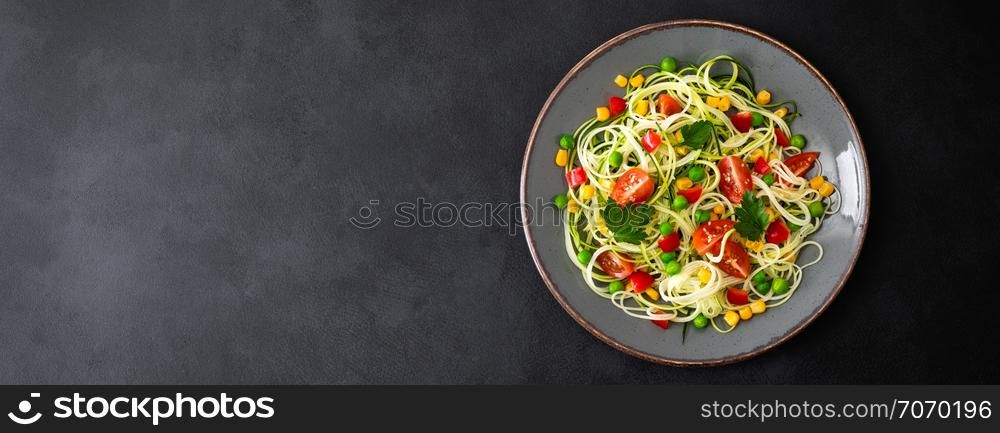Zoodlie, healthy vegan food - zucchini noodlie with fresh green peas, tomato, bell pepper and corn for lunch, view from above