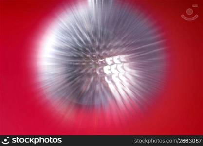 Zoom blur effect, silver sequin chritsmas ball, over red background