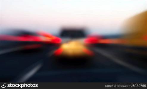Zoom blur of rear lights of cars in motion on highway.