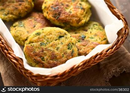 Zucchini, couscous and parsley fritters in basket, photographed with natural light (Selective Focus, Focus in the middle of the first fritter)