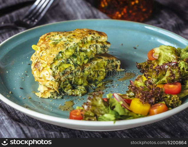 Zucchini Pancakes With salad at blue plate