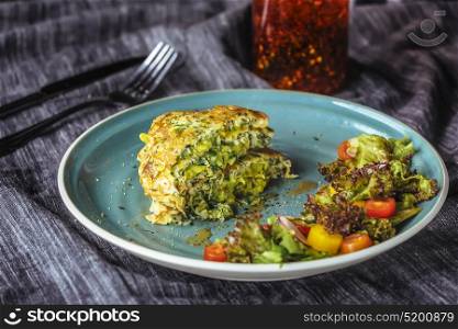 Zucchini Pancakes With salad at blue plate