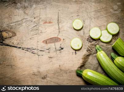Zucchini sliced and whole of the old fabric. On wooden background.. Zucchini sliced and whole of the old fabric.