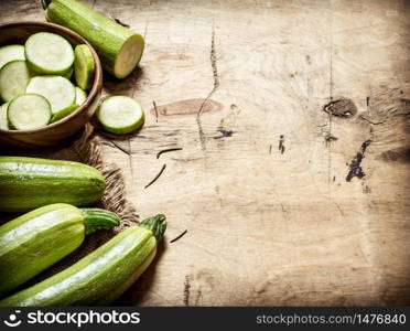 Zucchini sliced and whole of the old fabric. On wooden background.. Zucchini sliced and whole of the old fabric.