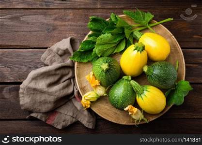 Zucchini with leaves and flowers on dark wooden rustic background