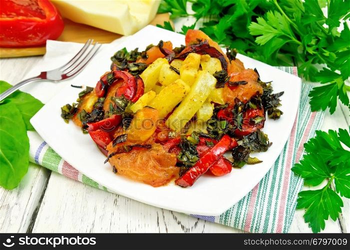 Zucchini with tomatoes, pepper and sorrel fried Greek in a plate on a napkin, fork, parsley on the background light wooden boards