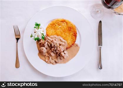 Zurich style veal meat stew with creamy mushroom gravy sauce and fried rosti potato, Local Swiss cuisine in white plate